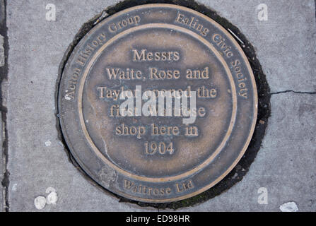 Marciapiede lapide segna il sito del primo waitrose shop, dal 1904, acton high street, Acton, Londra, Inghilterra Foto Stock