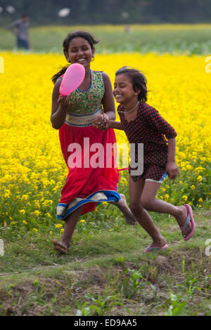 Bangladesh. 02Jan, 2015. I bambini che giocano nel campo passň in rassegna in Bangladesh. In inverno si approfondisce in questo paese che si trova athwart il tropico del Cancro e il paesaggio è colorata, in tutto il paese, con vaste fasce di campi di senape, prestito un impressionante, quasi magico di qualità quasi infinite viste attraverso le pianure deltizio. Foto Stock