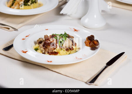 Fette di arrosto di manzo con erbe aromatiche, saporito riso e verdure servita su un tavolo in un ristorante per un pasto gustoso Foto Stock