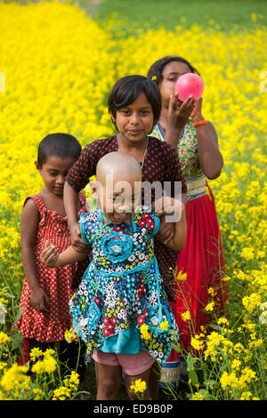 Bangladesh. 02Jan, 2015. I bambini che giocano nel campo passň in rassegna in Bangladesh. In inverno si approfondisce in questo paese che si trova athwart il tropico del Cancro e il paesaggio è colorata, in tutto il paese, con vaste fasce di campi di senape, prestito un impressionante, quasi magico di qualità quasi infinite viste attraverso le pianure deltizio. Credito: zakir hossain chowdhury zakir/Alamy Live News Foto Stock