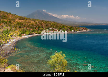 Vista del Monte Agung (3031m) e Jemulek beach & borgo nei pressi di Amed sulla costa nordorientale di Bali, Indonesia. Foto Stock