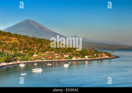 Vista del Monte Agung (3142) e Jemulek beach e il borgo nei pressi di Amed sulla costa nordorientale di Bali, Indonesia. Foto Stock