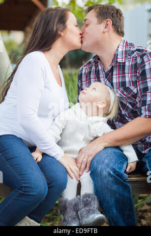 Felice coppia incinta baci al di fuori come bambina orologi. Foto Stock