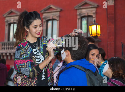 Le facce sono dipinte come teschi come le persone si trasformano in CATRINAS durante il giorno dei morti - San Miguel De Allende, MEX Foto Stock