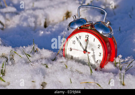 Vintage anno nuovo orologio sveglia su fresco dicembre neve invernale. Anno nuovo concetto Foto Stock