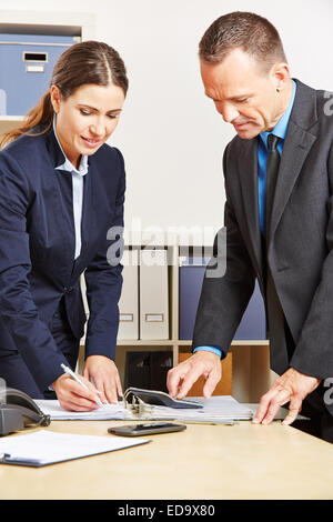 I dipendenti di una banca facendo il calcolo finanziario per un mortage Foto Stock