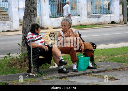 Due donne cubane seduti in una piazza cittadina di parlare nel quartiere Vedado dell Avana Foto Stock