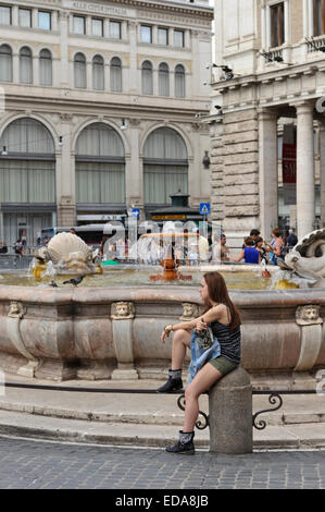 Un giovane adolescente seduta dalla fontana di Piazza Colonna, Roma, Italia. Foto Stock