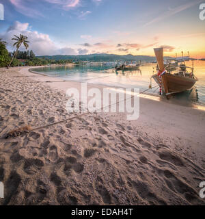 Una bella immagine del tramonto colorato con sky e longtail boat sul mare spiaggia tropicale. Della Thailandia Foto Stock