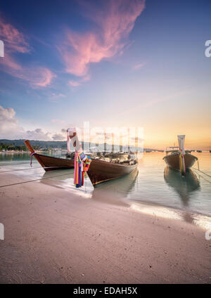 Una bella immagine del tramonto colorato con sky e longtail boat sul mare spiaggia tropicale. Della Thailandia Foto Stock