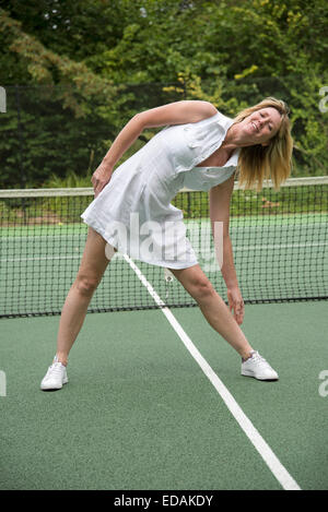 Sportive limbering fino su un campo da tennis un sano esercizio fisico e mantenersi in forma Foto Stock