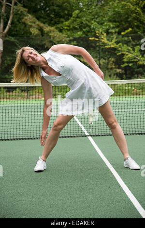 Sportive limbering fino su un campo da tennis un sano esercizio fisico e mantenersi in forma Foto Stock