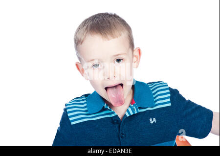 Ragazzo di 7 anni il suo incollaggio con la lingua fuori in studio Foto Stock