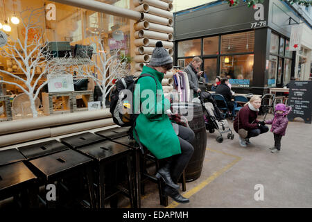 Persone che controllano i propri telefoni cellulari in Brixton Village London Foto Stock