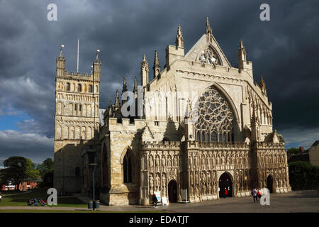 Una Cattedrale medievale che mostra il fronte ovest illuminate dal sole basso con nuvole scure nel cielo. Foto Stock