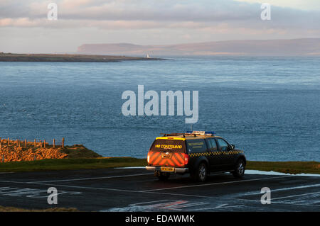 Testa Duncansby, Caithness in Scozia. 04 gen 2015. HM Coastguard veicolo a testa Duncansby come la ricerca continua per l'equipaggio mancante dalla nave cargo Cemfjord che affondò nel Pentland Firth ieri. Nella distanza, su Pentland Firth, è Hoy nelle isole Orkney e l isola di stroma con il suo faro. A testa Duncansby, Caithness in Scozia. Foto Stock