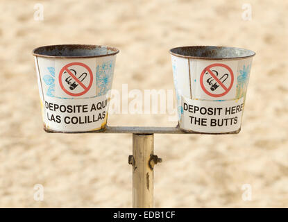 Contenitori per lo smaltimento dei mozziconi di sigaretta sulla spiaggia in Spagna. Uno in inglese e l'altra in spagnolo. Foto Stock