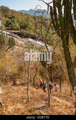 SWAZILAND, AFRICA - Persone escursionismo in Phophonyane Riserva Naturale con cascata in distanza. Foto Stock