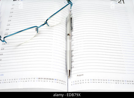 Pianificazione giornaliera con gli occhiali e la penna sul tavolo Foto Stock