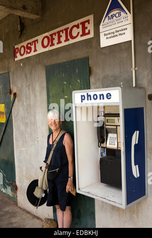 Maurizio, Britannia, zucchero di canna villaggio fabbrica, sorridente donna anziana ospite a Phone Booth Foto Stock