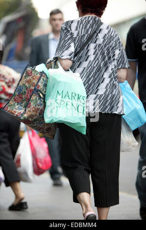 Foto di un Marks & Spencer shopper al di fuori di un negozio nel quartiere di Islington, Londra. Foto Stock