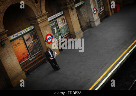 Un " commuter " lone wiating sul quartiere di Paddington e la linea metropolitana Circle piattaforma. Foto Stock