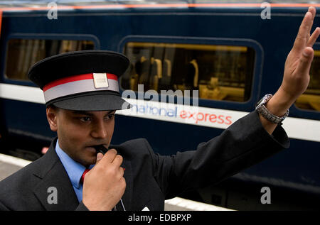 Un treno di segnali di guardia accanto a un National Express treno alla stazione Kings Cross, London. Foto Stock