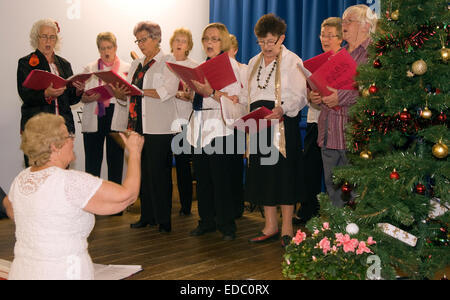 Le donne di istituto (wi) membri cantare a tempo di Natale in village hall di whitehill, vicino bordon, hampshire, Regno Unito. Foto Stock