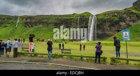 I turisti a scattare foto a cascata Seljalandsfoss, Islanda Foto Stock