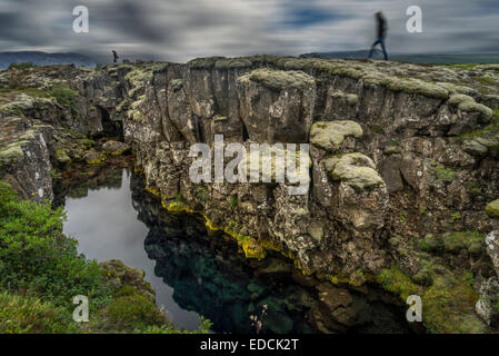 Persone in piedi dalla fessura Flosagja, Thingvellir National Park, Islanda Foto Stock