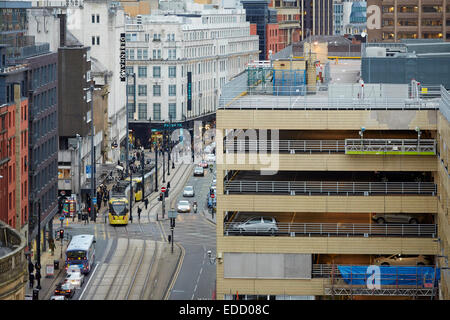 Manchester High Street in Shudehill area del centro della città, una del tram Metrolink si arresta in corrispondenza di luci, incorniciato da Arndale par auto Foto Stock