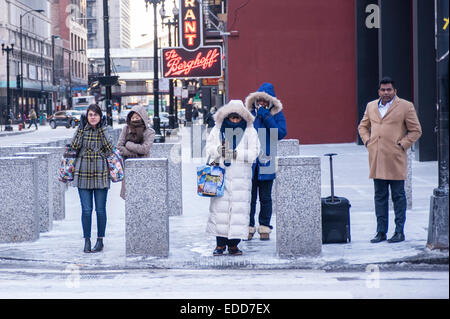 Chicago, Stati Uniti d'America, 5 gennaio 2015. Dopo una notte di neve, la gente in città il ritorno al lavoro dopo le vacanze sperimentato temperature di -16C (-4F). Più grave e più fredde meteo noto come il " Alberta Clipper' è previsto. Nella foto: i " commuters " lotta per mantenere in caldo. Credito: Stephen Chung/Alamy Live News Foto Stock