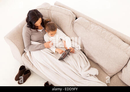 Vista aerea della madre e figlia seduta sul lettino usando computer tablet Foto Stock