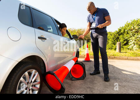 Driver per studenti rendendo errore durante un ciclo di prova eseguito su traffico coni Foto Stock