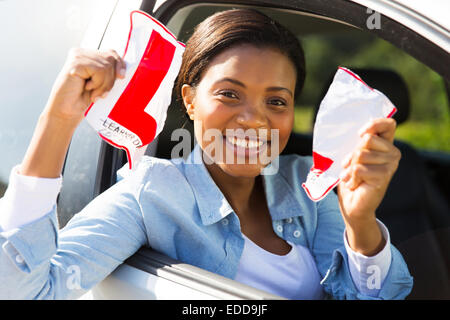 Felice africana driver femmina sistemando il suo segno L udienza in auto Foto Stock