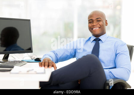 Rilassata imprenditore nero seduto in un ufficio moderno Foto Stock