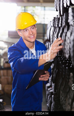 Felice giovane lavoratore in scarpe manufacturing company Foto Stock