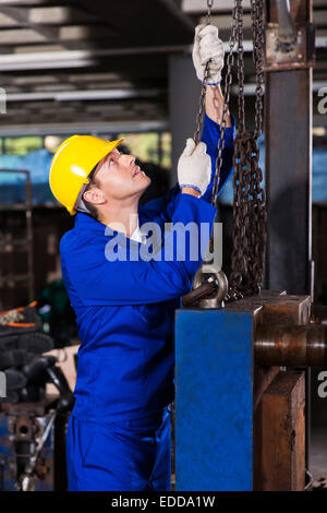 Operaio industriale in uniforme di catene di trascinamento Foto Stock