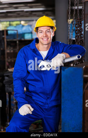 Maschio lavoratore manuale tenendo la chiave in fabbrica Foto Stock