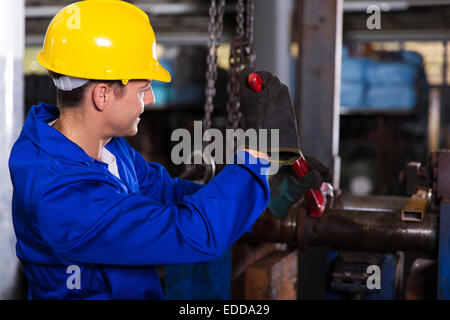 Meccanico con Monkey Wrench riparazione di tubazioni in fabbrica Foto Stock