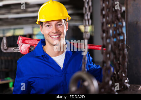 Operaio industriale che trasportano scimmia chiave in officina Foto Stock