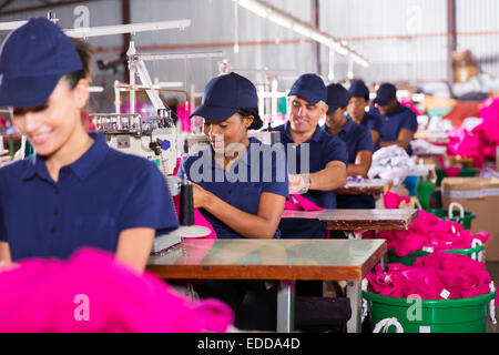 Gruppo multirazziale lavoratori in fabbrica la cucitura in fabbrica di abbigliamento Foto Stock