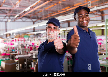 Allegro supervisori di fabbrica dando pollice in alto Foto Stock