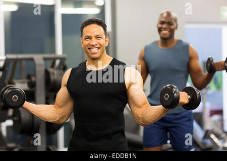 Fitness uomo di mezza età che esercitano con manubri in palestra Foto Stock
