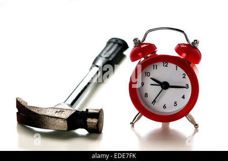 Un orologio e un martello, il concetto di disturbo che provoca la sveglia al mattino Foto Stock