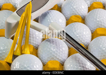 White palline da golf nella casella gialla e attrezzature da golf Foto Stock