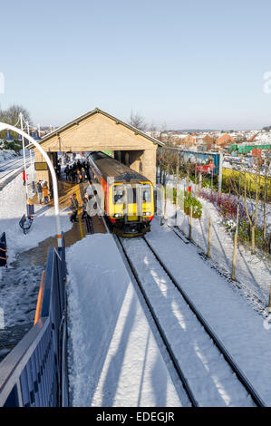 I passeggeri di salire sul treno dei pendolari in corrispondenza di una stazione locale dopo una caduta di neve a Mansfield Woodhouse, Nottinghamshire. Foto Stock