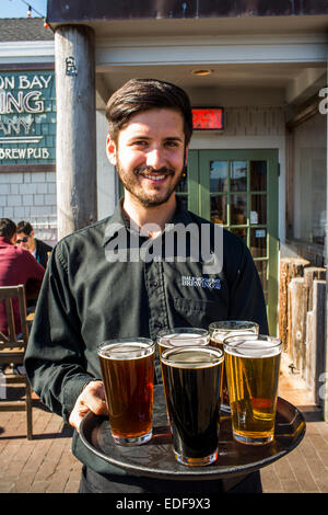 Un server può contenere una varietà di birre a Half Moon Bay Brewing Company in Half Moon Bay, California in una giornata di sole. Foto Stock