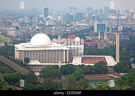 Lo smog che gravano su di Giacarta e vista sulla Moschea Istiqlal / Masjid Istiqlal, più grande moschea in Indonesia e nel Sud Est asiatico Foto Stock