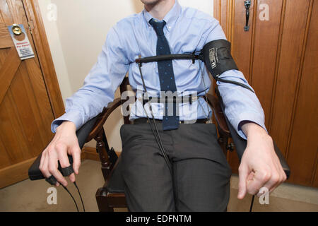 Uomo di essere esaminato usando un test di poligrafo lie detector macchina che confronta le risposte a domande selezionate per ottenere la verità Foto Stock